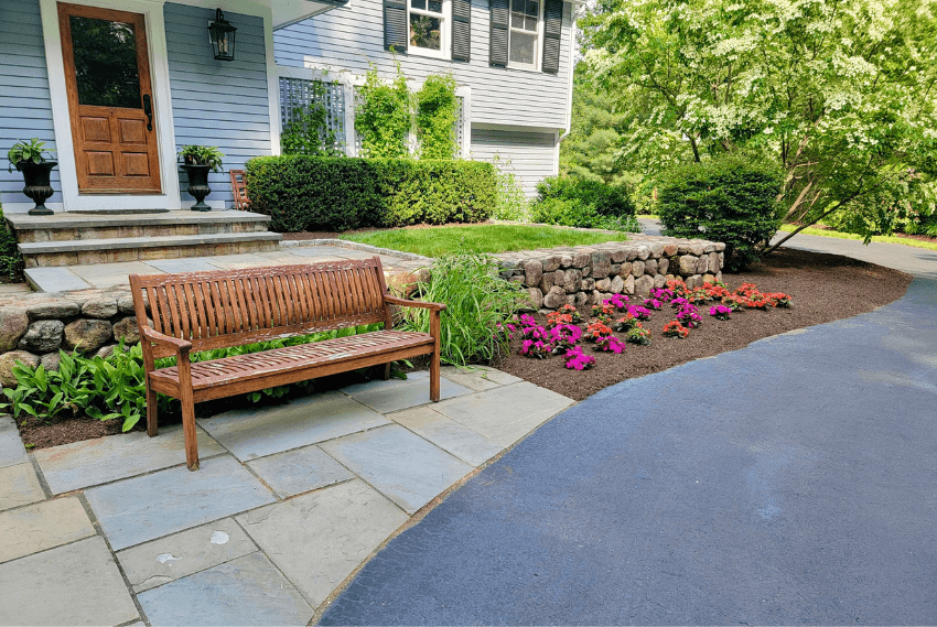 Example of properly mulched front yard landscape beds showing correct mulch coverage around plants and stone edging