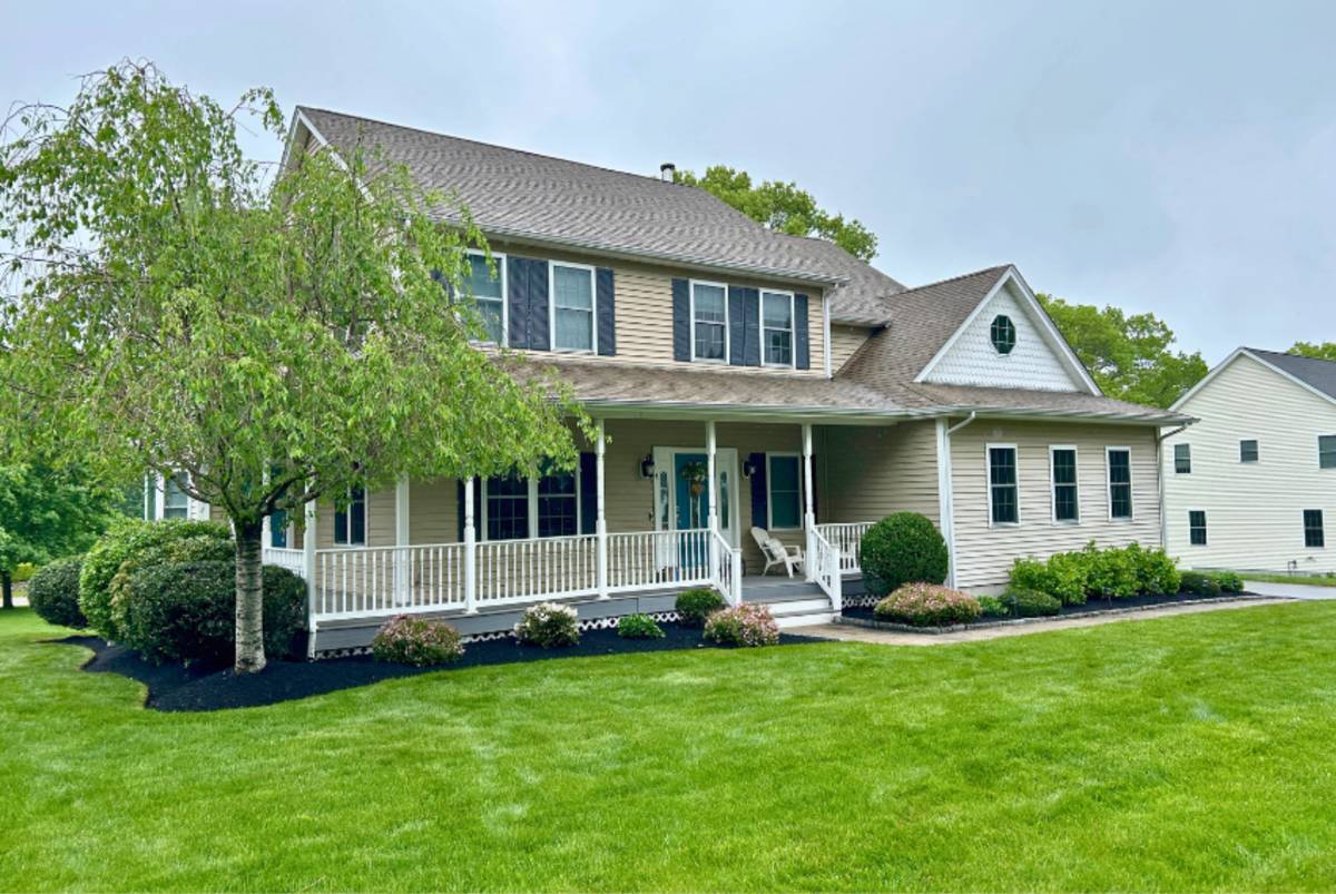 Fresh black mulch installed around foundation plantings of a Massachusetts home